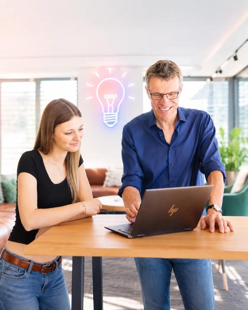 Zwei Personen arbeiten gemeinsam an einem Laptop